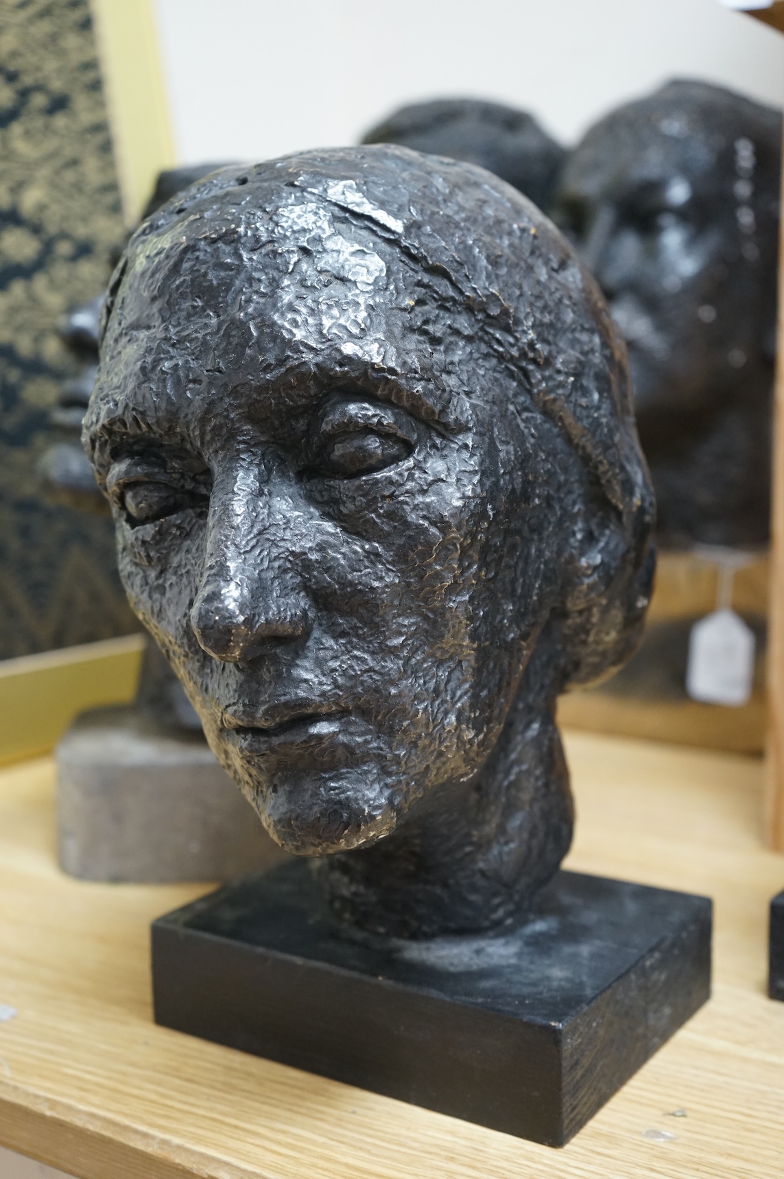 Six black painted composition heads, by Hazel Armour, tallest 49cm